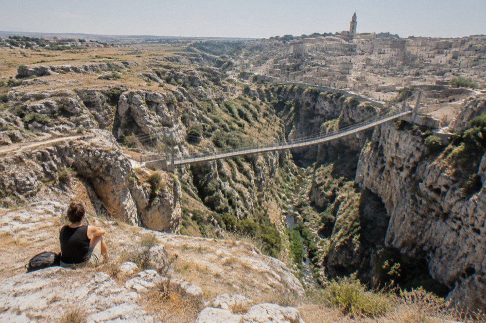 A suspension footbridge spanning the Gravina gorge between rocky cliffs