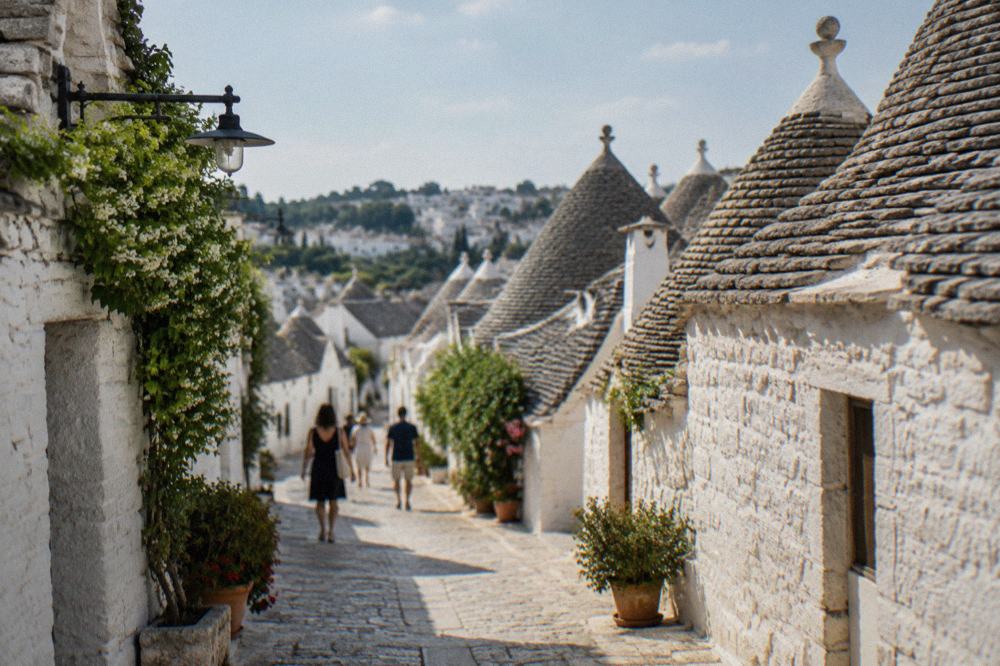White limestone trulli houses with conical roofs in a Puglian hill town