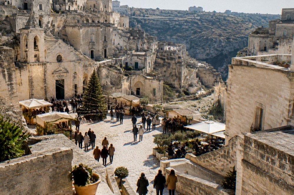 Festive lights and crowds in a stone square of Matera during December