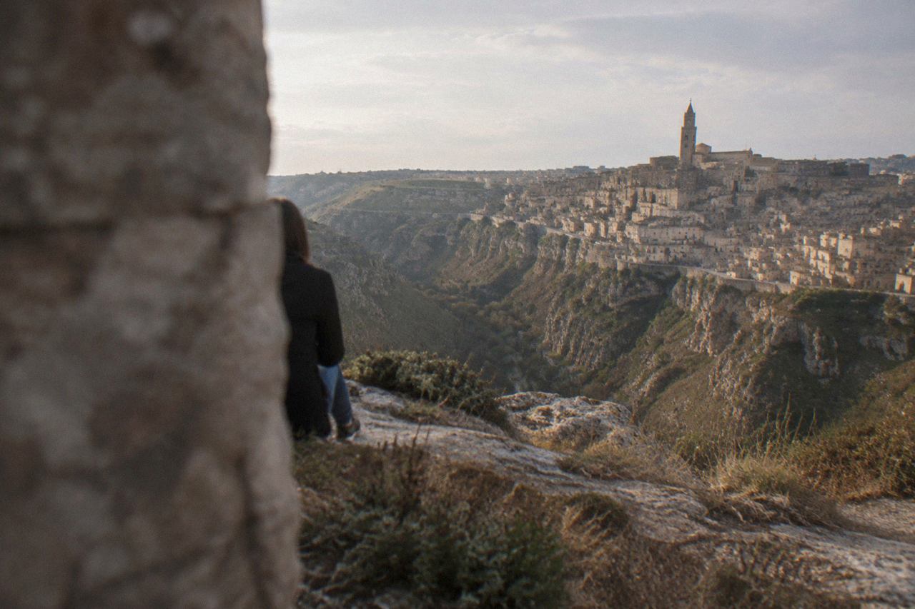 Cave houses and stone terraces of the Sassi district of Matera above the Gravina canyon at dusk