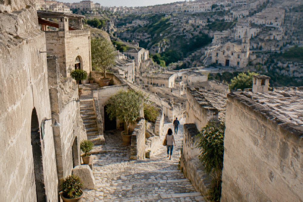 Narrow stepped lane between restored cave dwellings in the Sassi of Matera with stone stairways