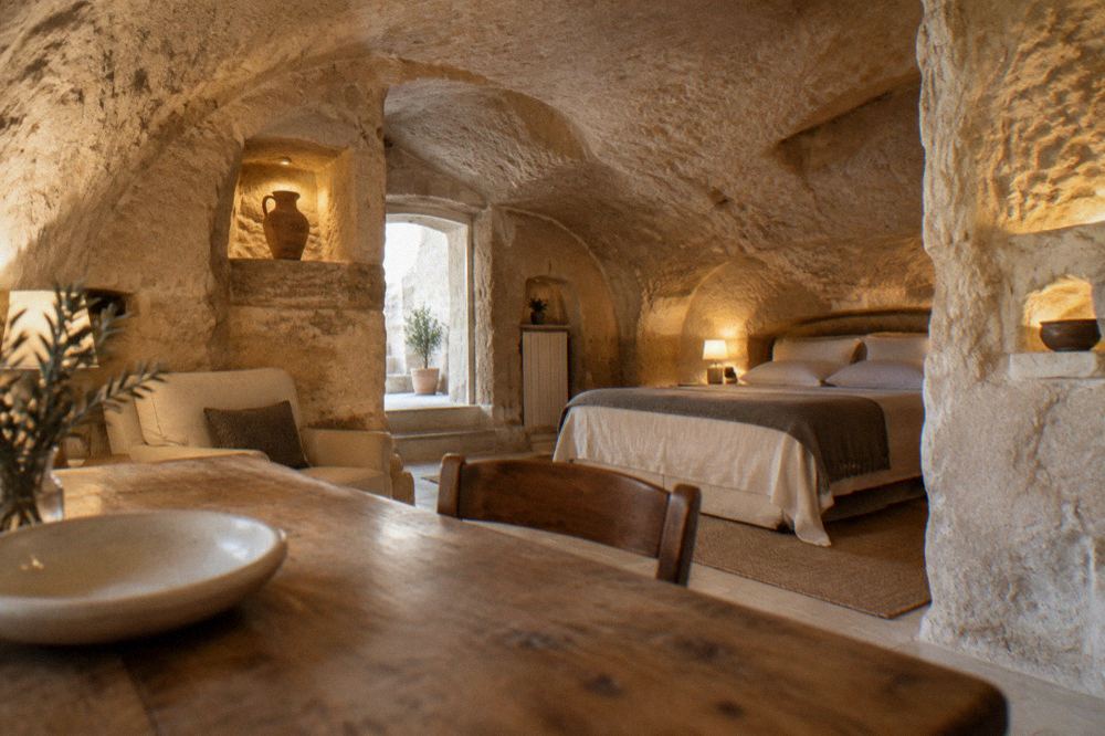 Interior of a restored cave room in Matera with vaulted tufa ceiling, arched niches and warm lighting