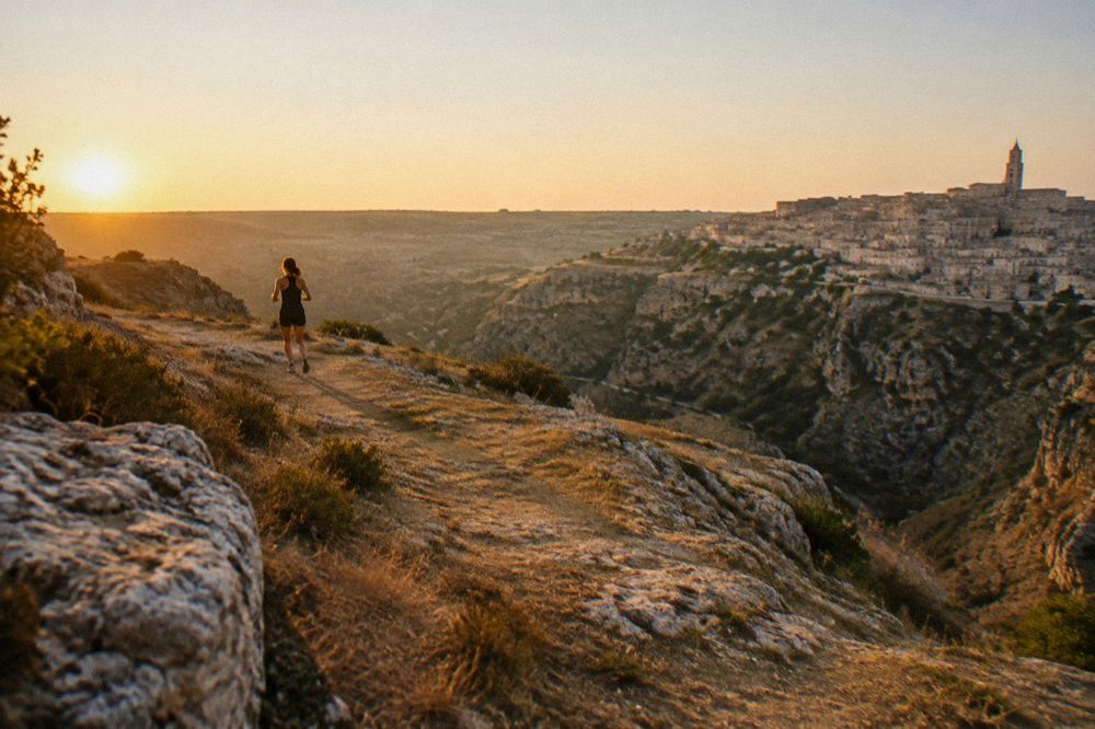 View from a Sassi hotel terrace across the Gravina canyon toward the Murgia plateau at sunrise