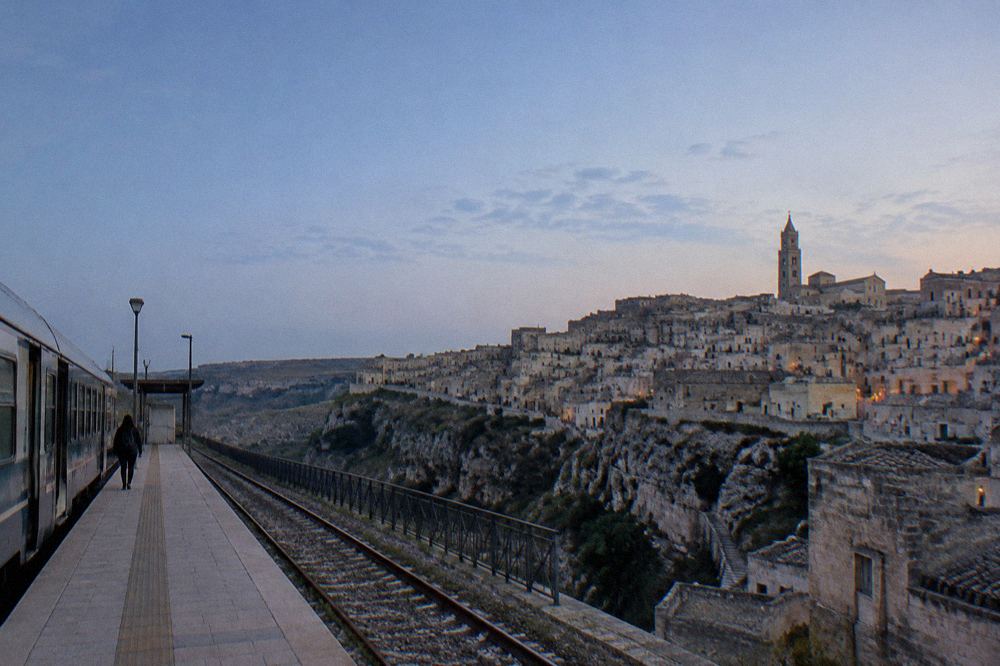 A single-track regional train at a small southern Italian station platform