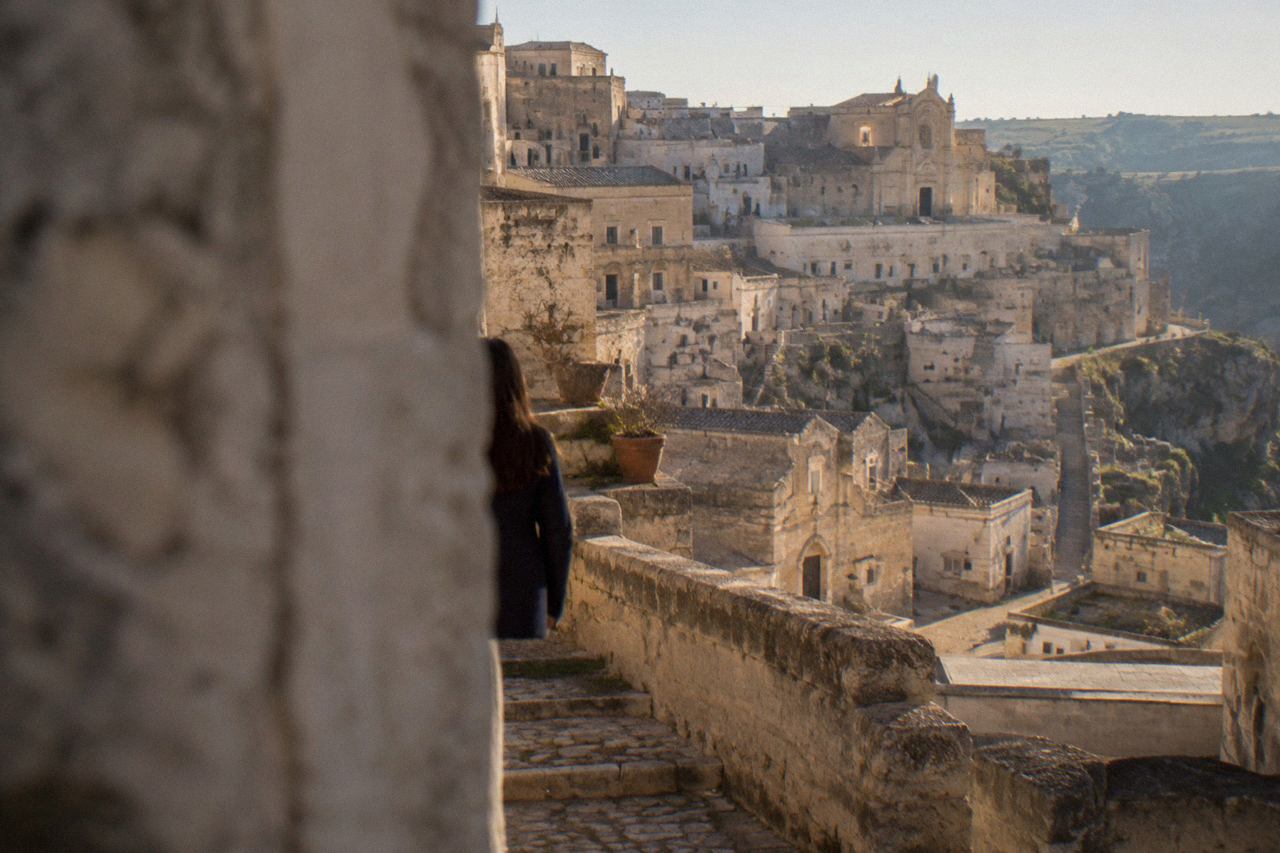 Cave dwellings and stone houses stacked along the edge of the Sassi district in Matera at golden hour