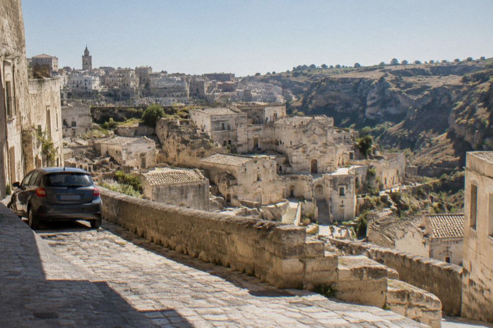 A car parked on a stone-edged street on the plateau above the Sassi in the early morning