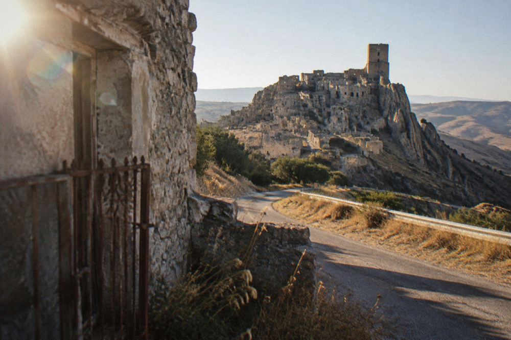A country road crossing the bare hills of the Basilicata interior under a clear sky