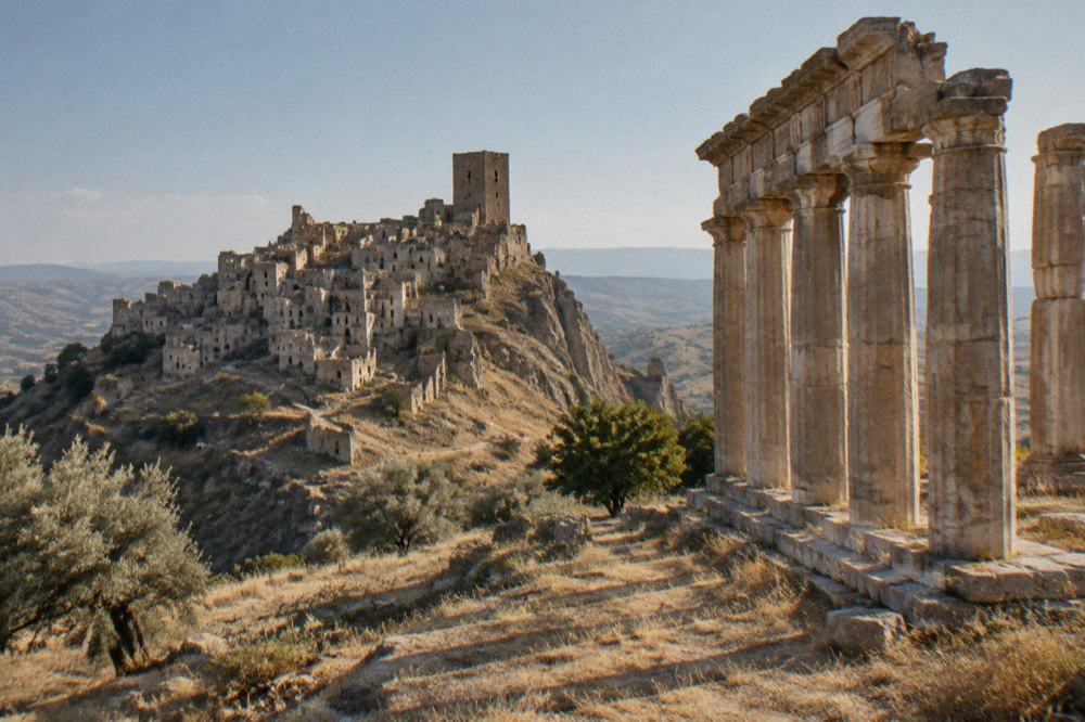 Doric columns of an ancient Greek temple standing in a field near the Ionian coast