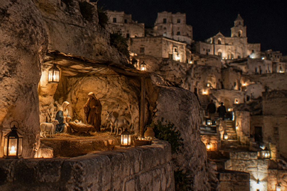 A lantern-lit nativity scene staged among the cave houses of the Sassi at night