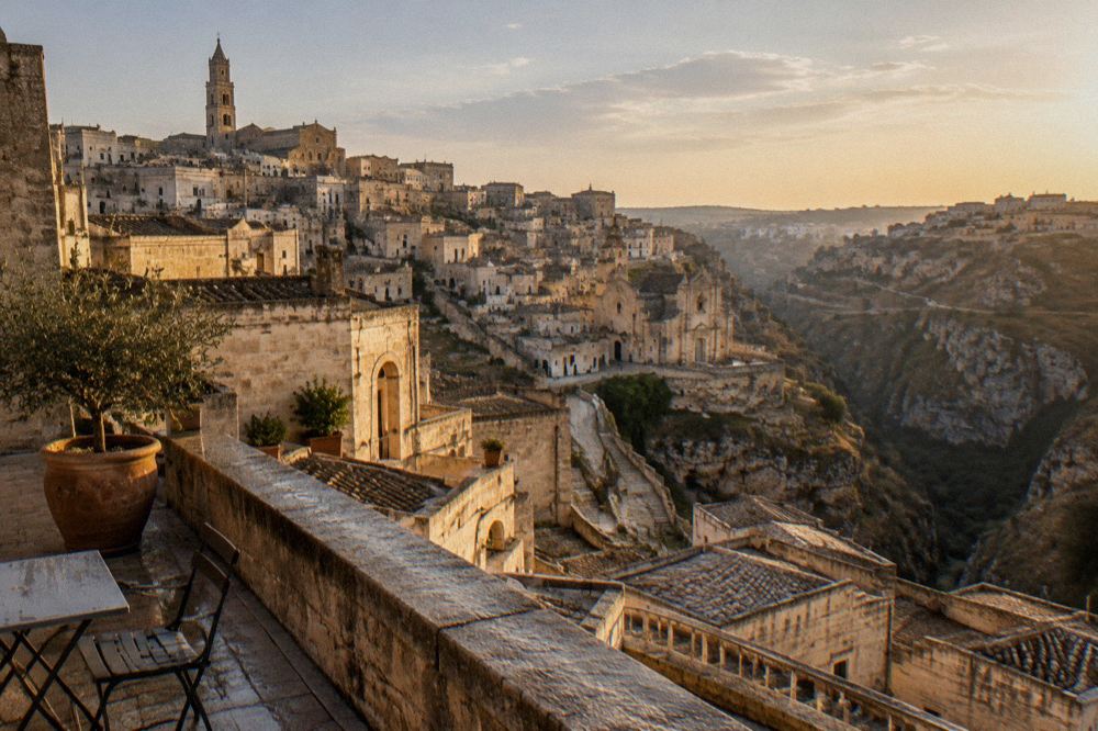 Warm evening light over the tiled roofs and canyon of Matera seen from a rooftop terrace