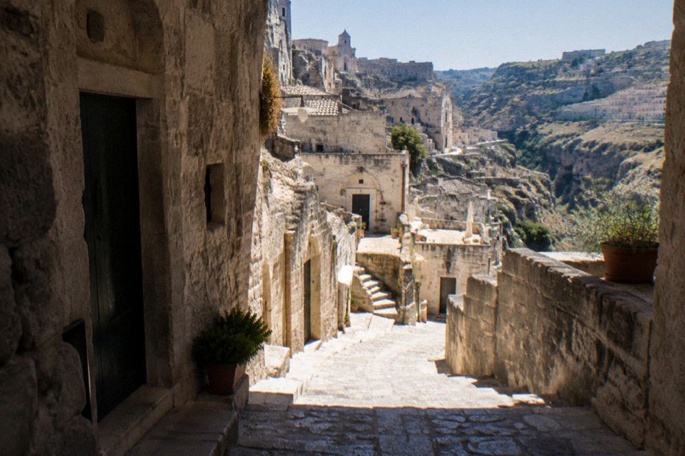 A narrow stone stairway lined with old cave-house doorways in the Sassi districts