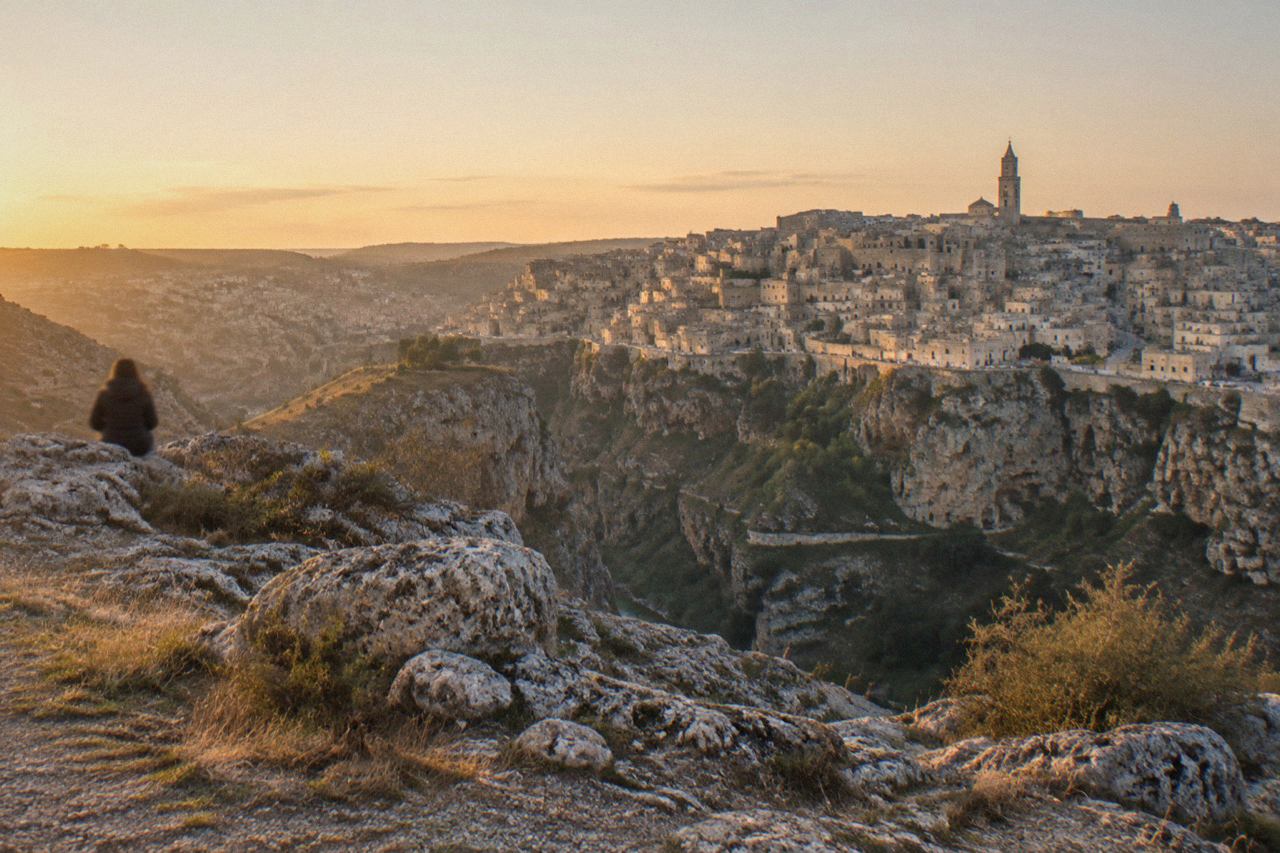The cave dwellings of the Sassi district of Matera rising above the Gravina canyon at golden hour