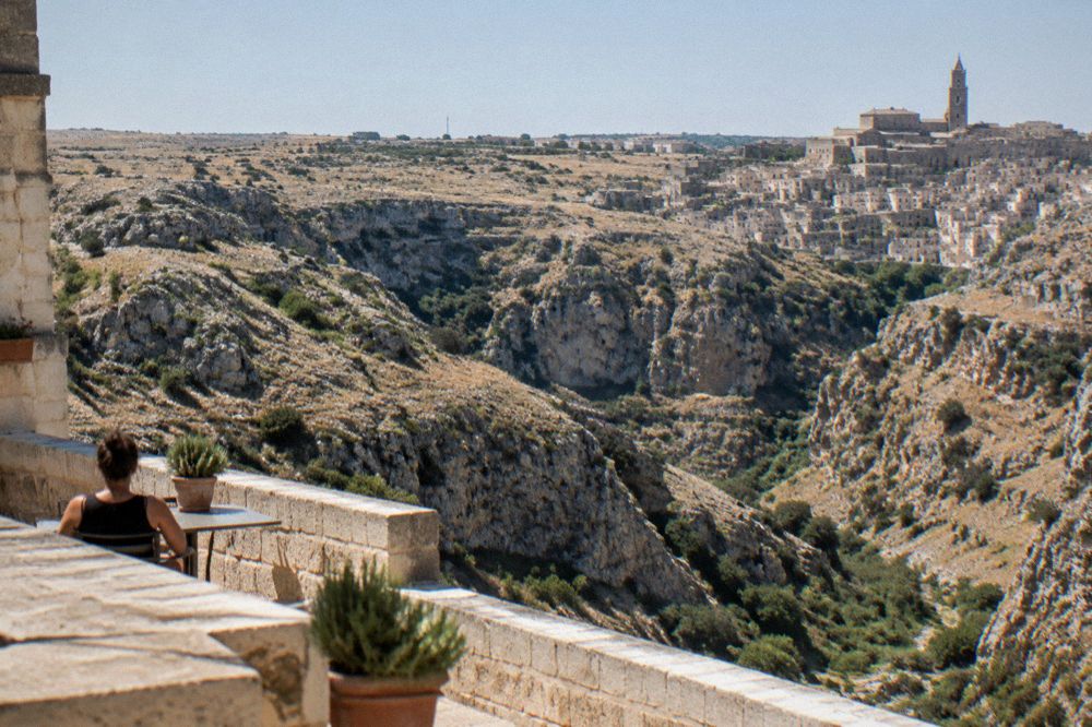 The view across the Gravina canyon from a rooftop terrace toward the Murgia plateau
