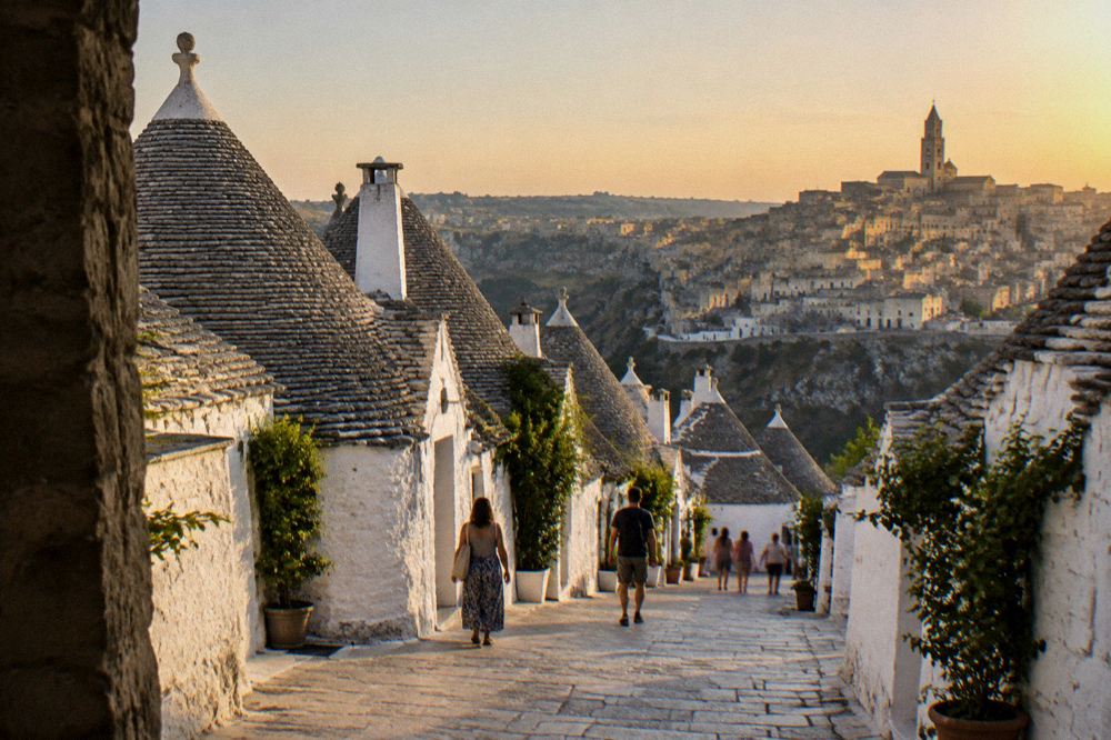 Trulli rooftops and the Matera skyline pictured side by side at dusk in southern Italy