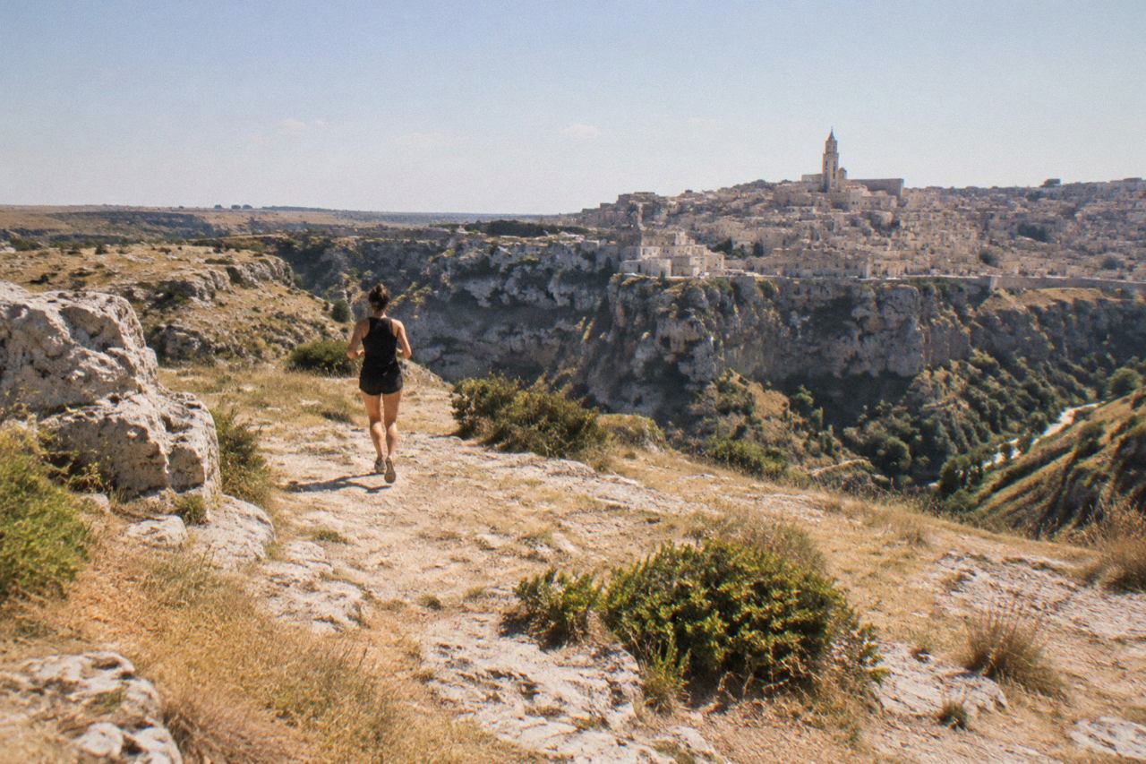 The cave houses of the Sassi district in Matera rising above the Gravina canyon in warm evening light