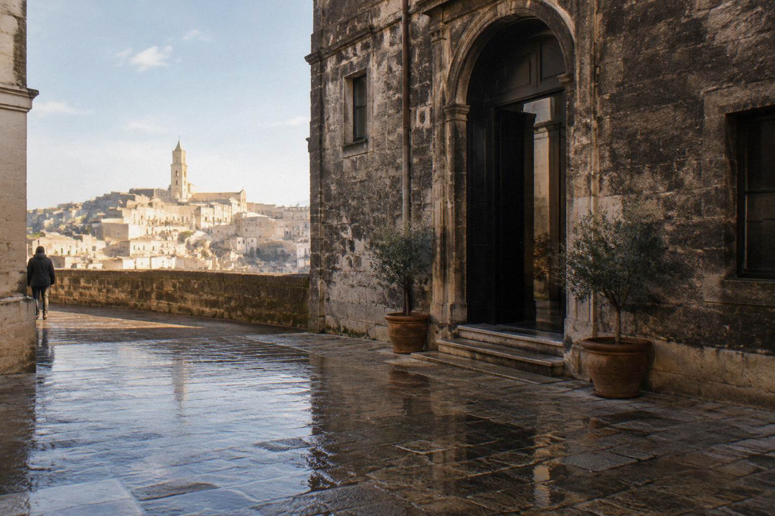 Wet cobbles and a dark stone facade of the old town after rain, reflections on the ground
