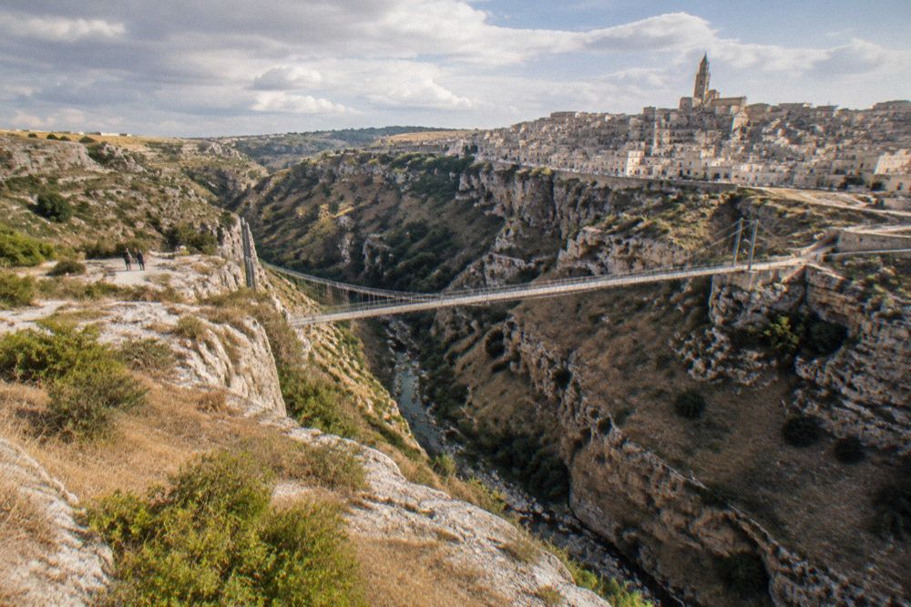 A suspension footbridge spanning the Gravina canyon between rocky slopes