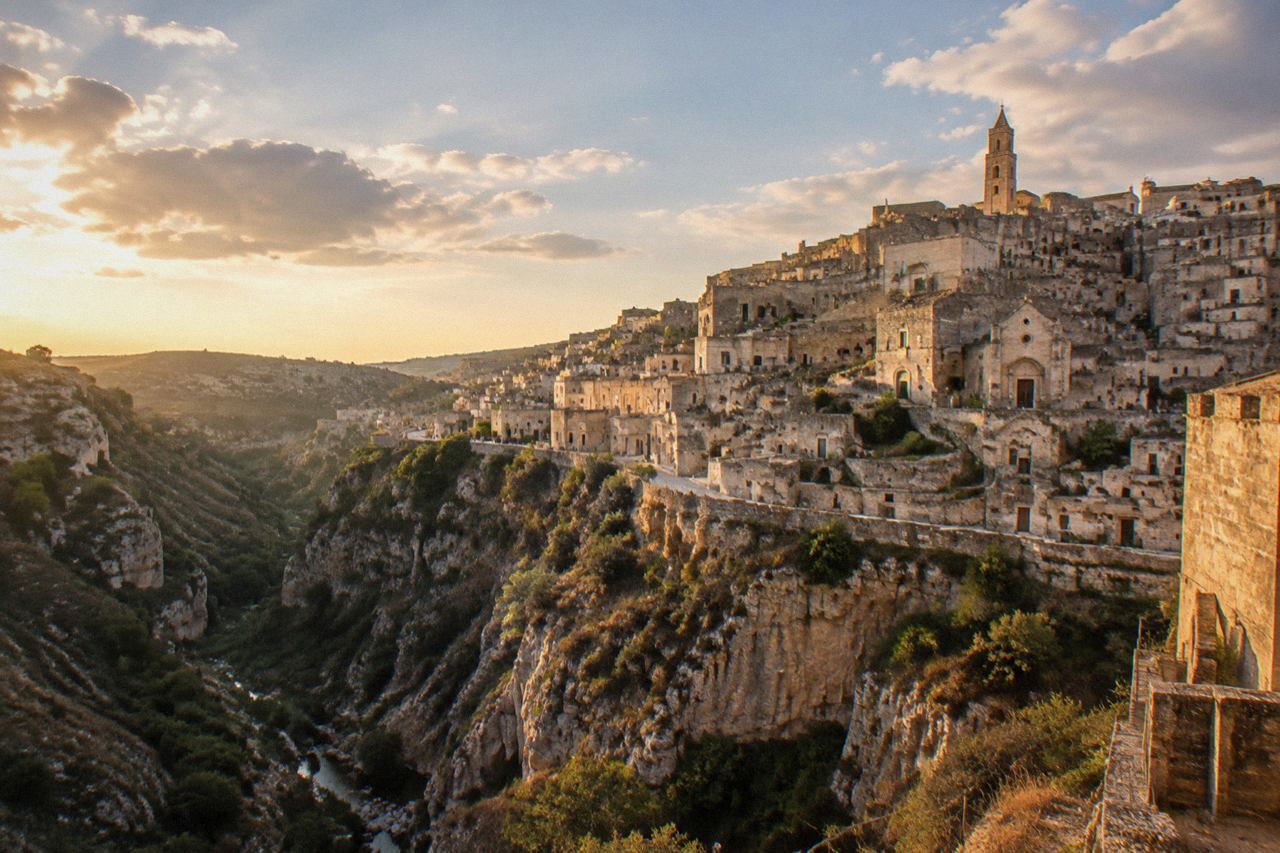The Sassi cave districts of Matera seen from across the Gravina canyon at golden hour