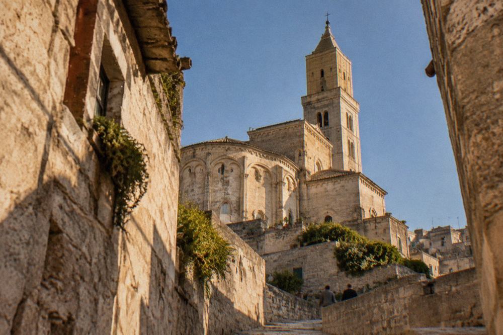 The Romanesque apse and bell tower of Matera Cathedral seen from a Sassi lane