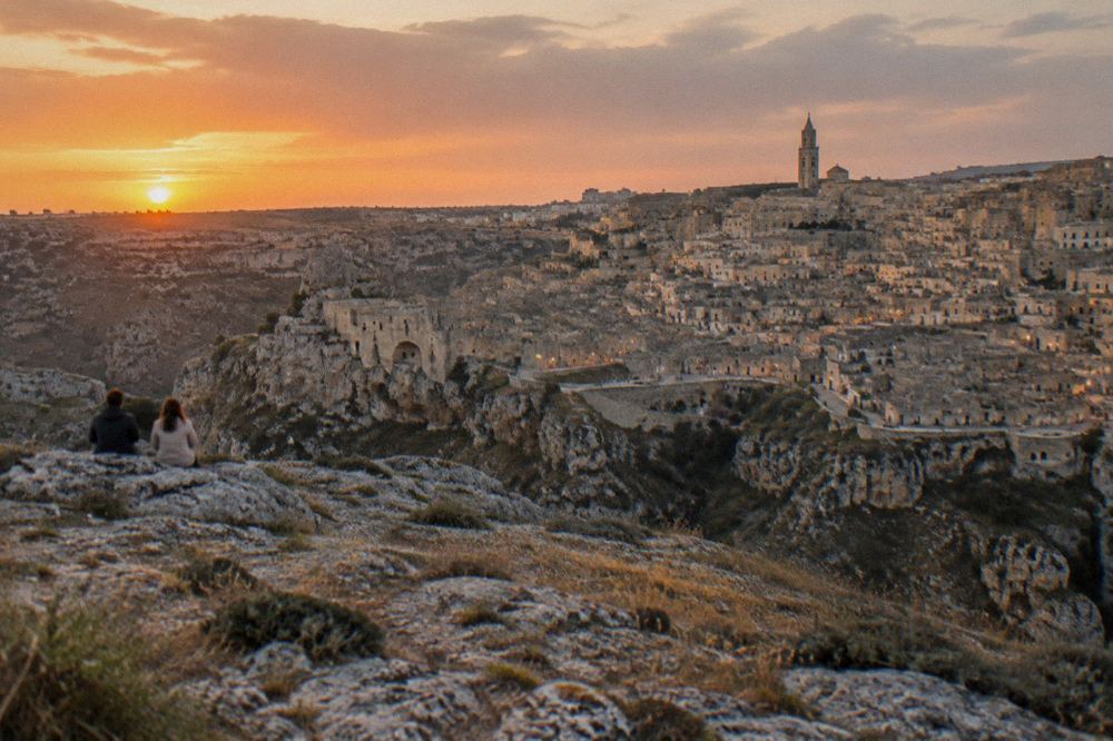 The Sassi of Matera seen at sunset from a rocky viewpoint on the Murgia plateau