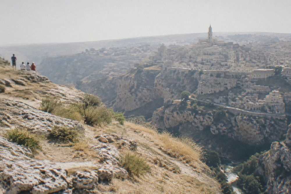 Pale limestone rock churches carved into the cliff face above the Gravina gorge