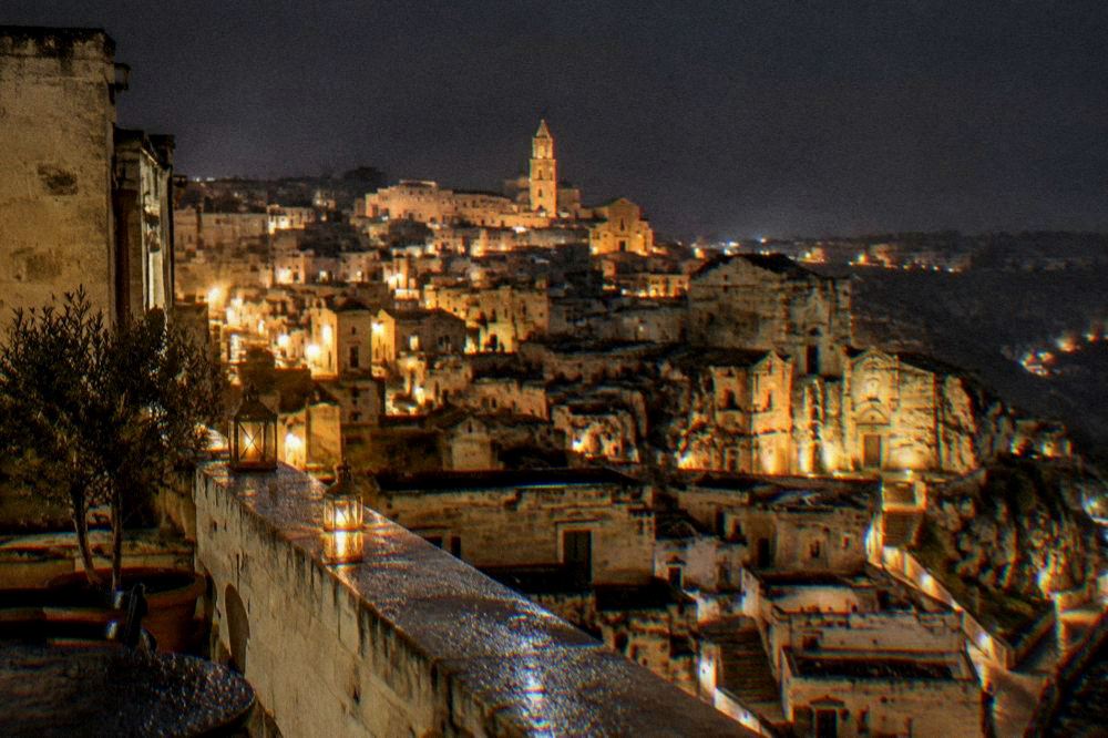 The floodlit Sassi of Matera seen from a rooftop terrace after dark