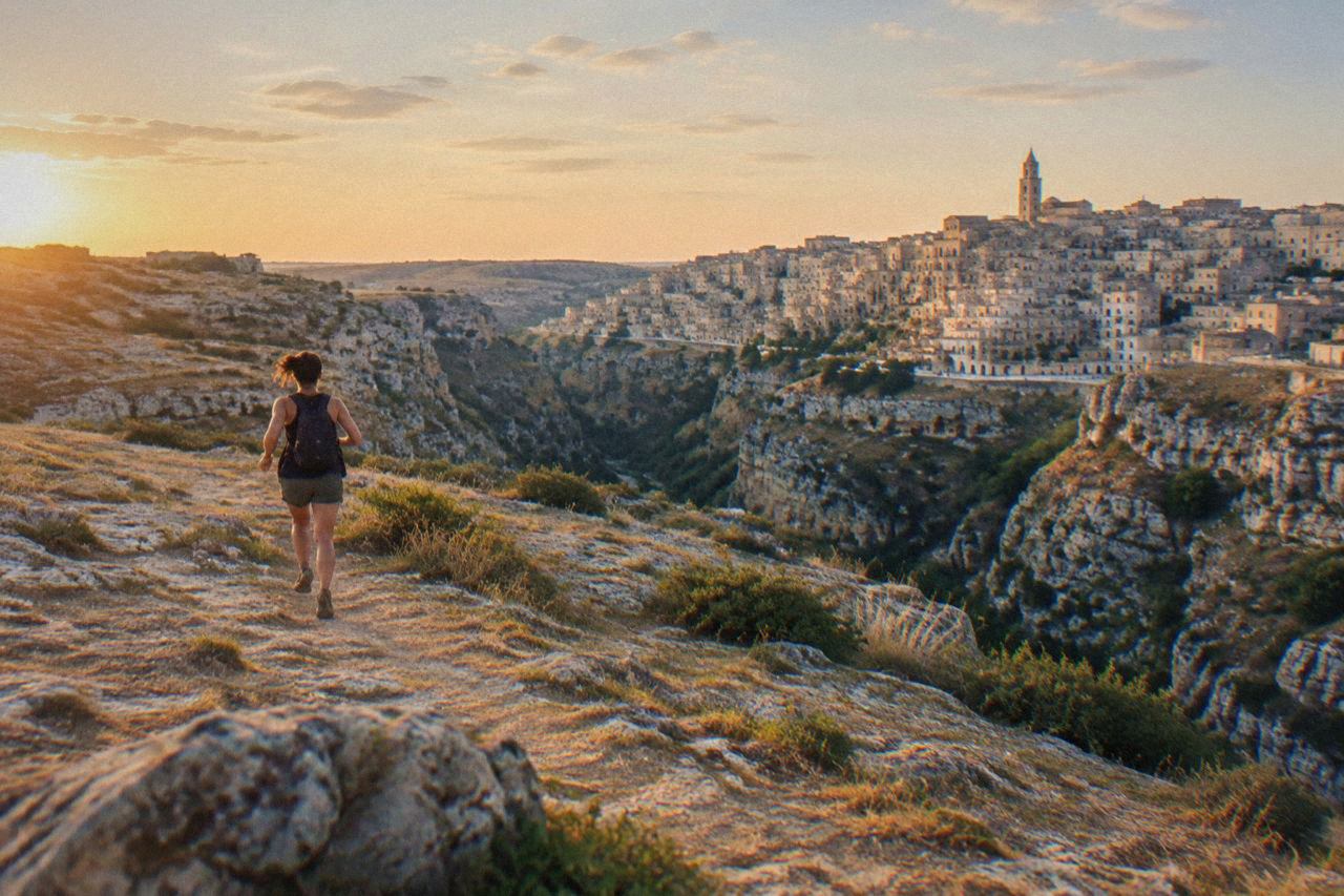 Panoramic view of the Sassi cave districts of Matera rising above the Gravina canyon at golden hour