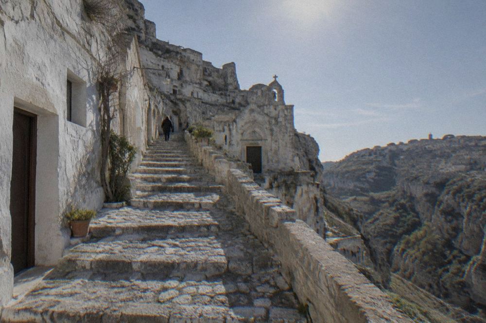 Stepped stone lane in Sasso Caveoso with cave doorways and whitewashed walls in daylight