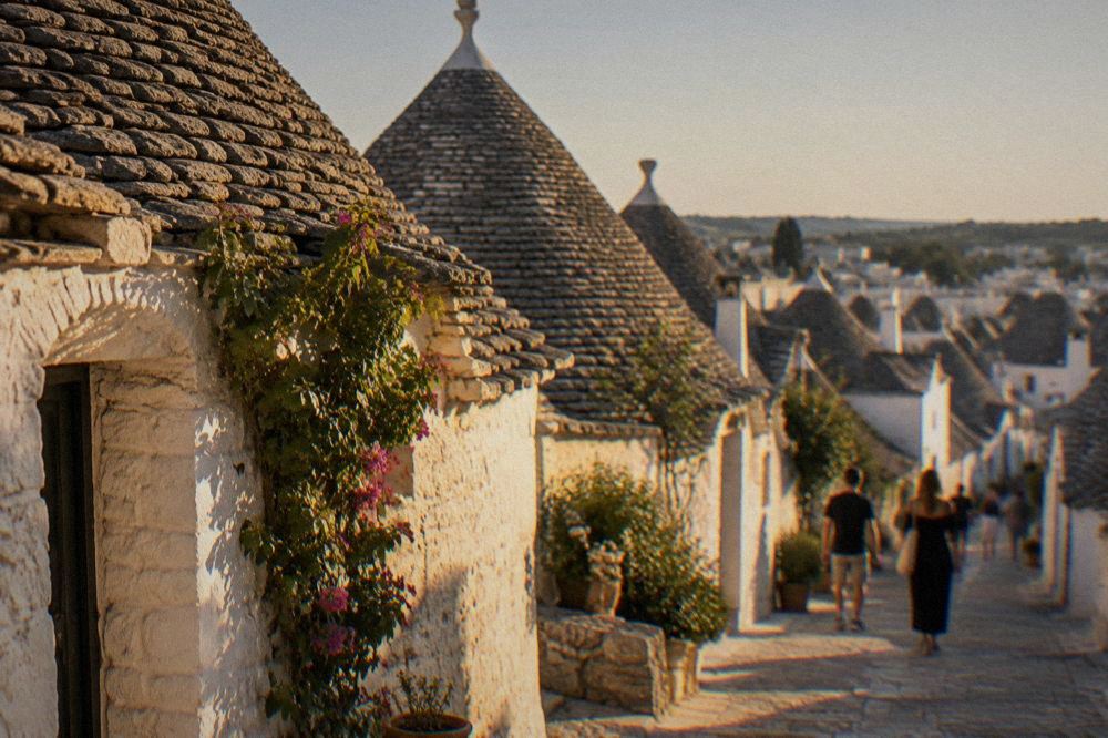 Whitewashed trulli houses with conical stone roofs in Alberobello under a clear sky