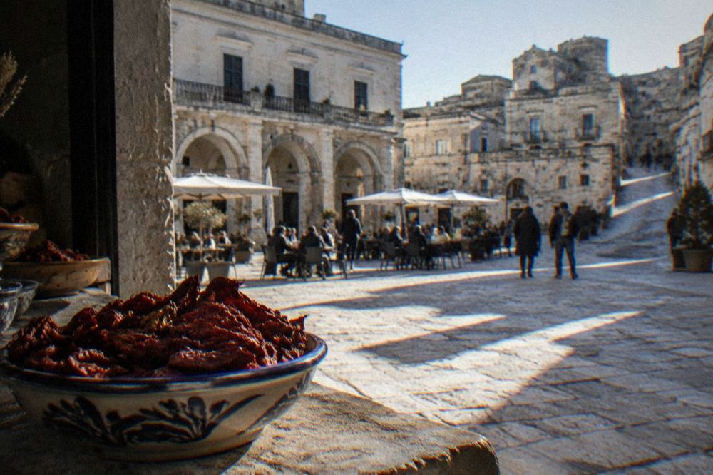 Dried red cruschi peppers in a ceramic bowl on a stone counter