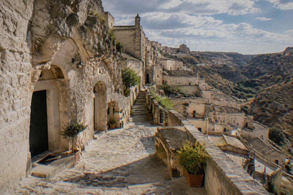 A narrow stone lane in Sasso Barisano with cave doorways carved into the rock face